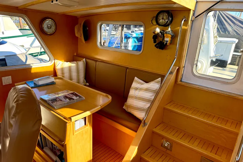 Slide: The Image of Cozy 1998 Waterline Pilothouse interior with dining area, wooden accents, and nautical decor. - 8