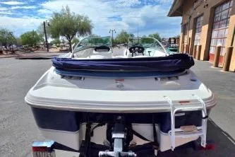 Slide: The Image of 2012 Four Winns H180LE boat, rear view, parked outdoors near a building. - 3