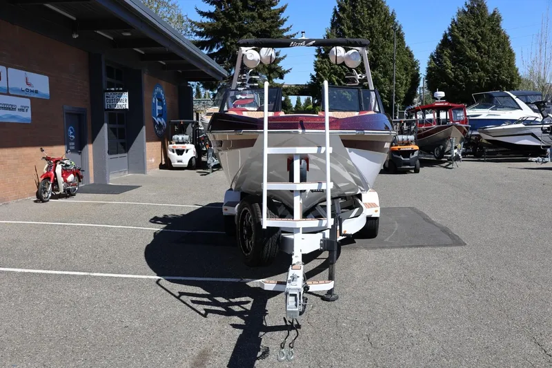 Slide: The Image of 2022 Tigé 25ZX boat on trailer in dealership parking lot. - 13