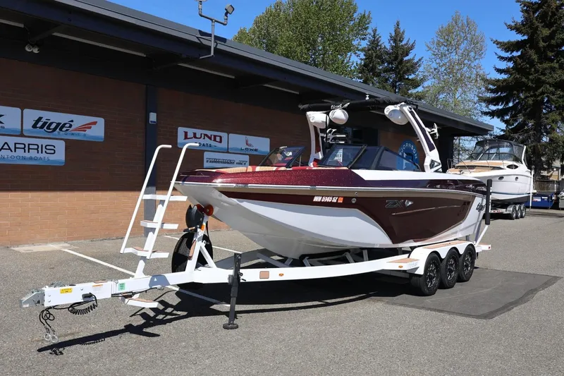 Slide: The Image of 2022 Tigé 25ZX boat on trailer outside dealership, sunny day. - 15