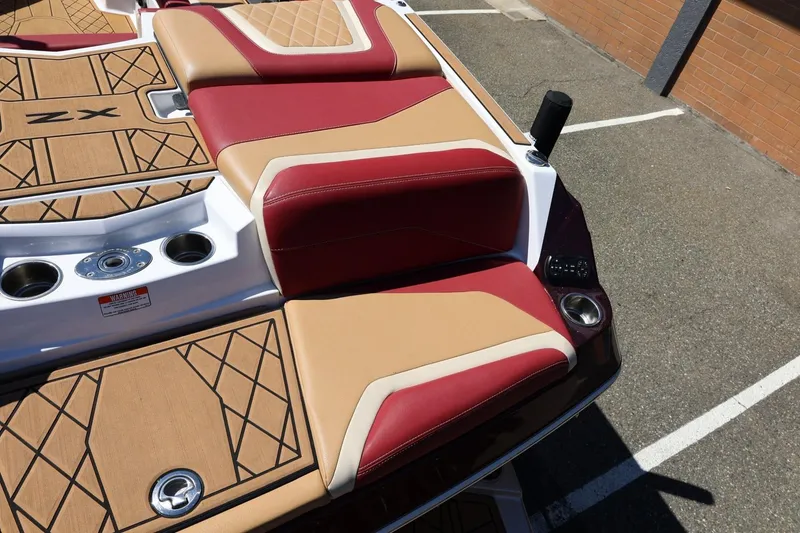 Slide: The Image of 2022 Tigé 25ZX boat with red and tan seating, cup holders, and stylish deck design. - 21