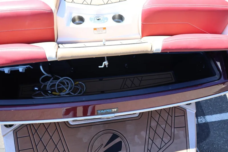 Slide: The Image of 2022 Tigé 25ZX boat interior with red seating and storage compartment. - 23