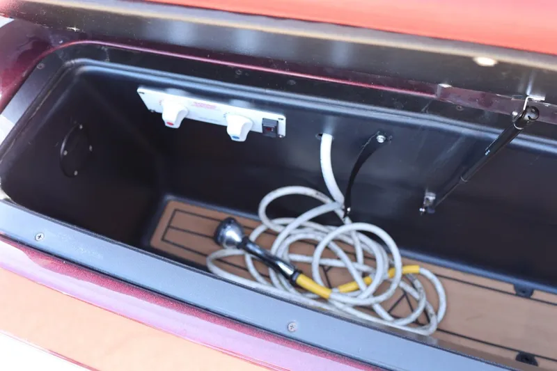 Slide: The Image of Storage compartment of 2022 Tigé 25ZX boat with coiled rope and controls. - 24