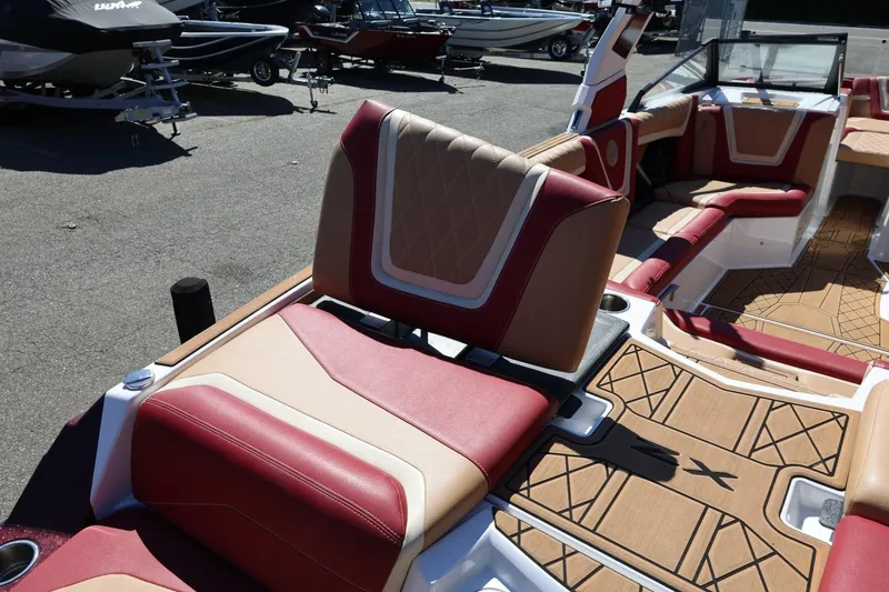 Slide: The Image of 2022 Tigé 25ZX boat interior with red and beige seating, showcasing luxury design. - 25