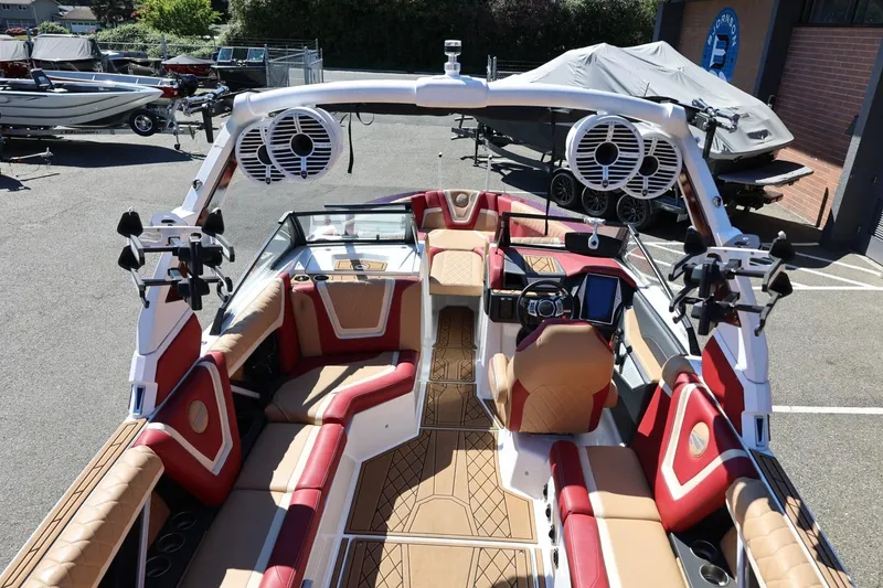 Slide: The Image of 2022 Tigé 25ZX boat interior with red and tan seating, advanced dashboard, and tower speakers. - 29