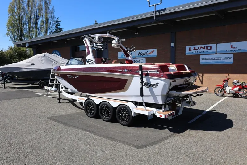 Slide: The Image of 2022 Tigé 25ZX boat on trailer at dealership, sunny day. - 3