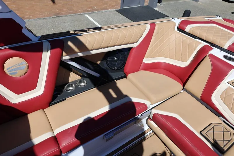 Slide: The Image of 2022 Tigé 25ZX boat interior with red and beige leather seating and cup holders. - 34