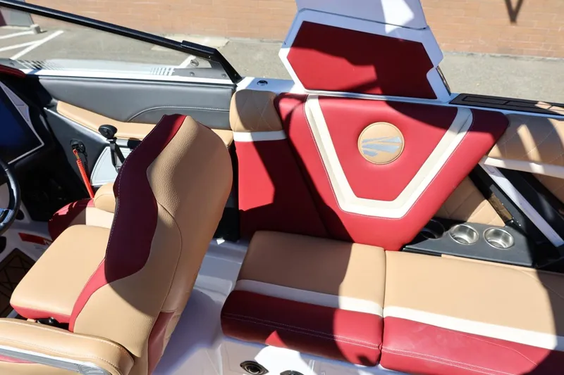 Slide: The Image of 2022 Tigé 25ZX boat interior with red and tan seating, cup holders, and stylish design. - 35