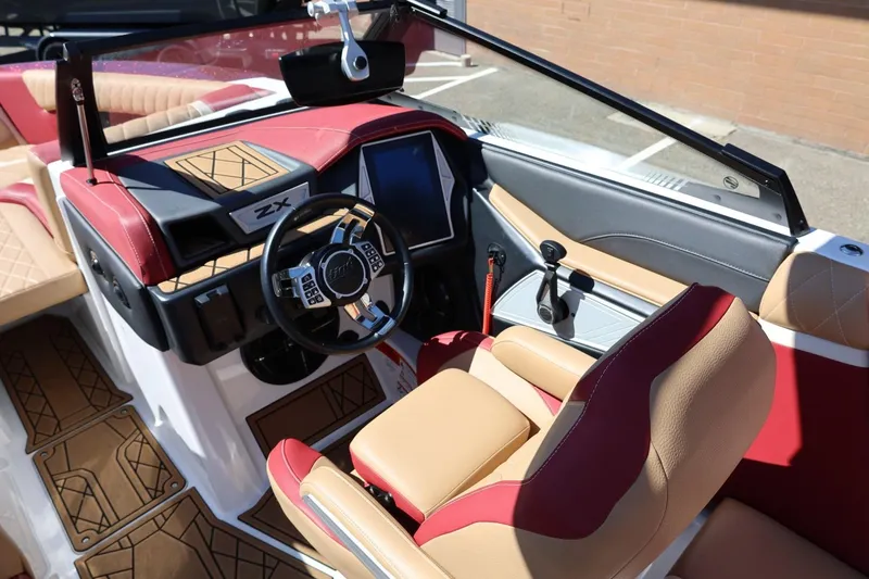 Slide: The Image of 2022 Tigé 25ZX boat interior with red and tan leather seats, modern dashboard. - 36