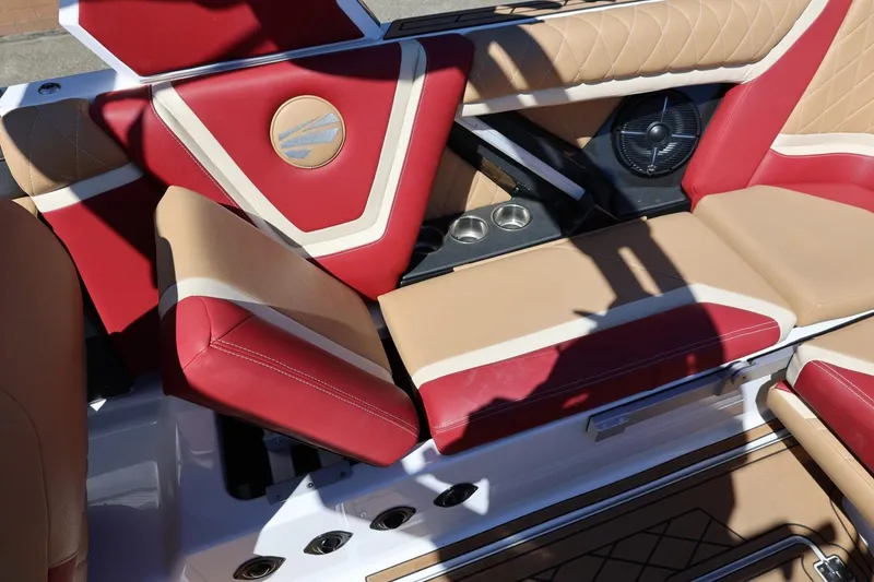 Slide: The Image of 2022 Tigé 25ZX boat interior with red and beige seating, cup holders, and speaker. - 37