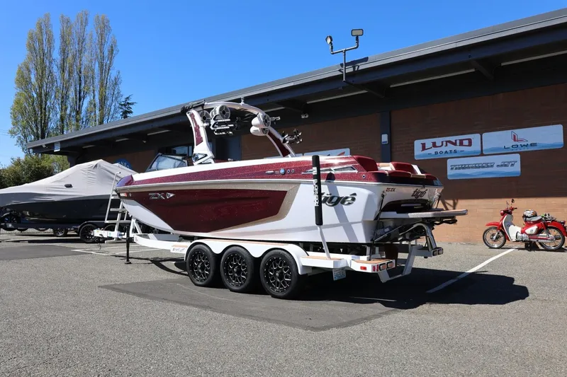 Slide: The Image of 2022 Tigé 25ZX boat on trailer, parked outside a dealership. - 4