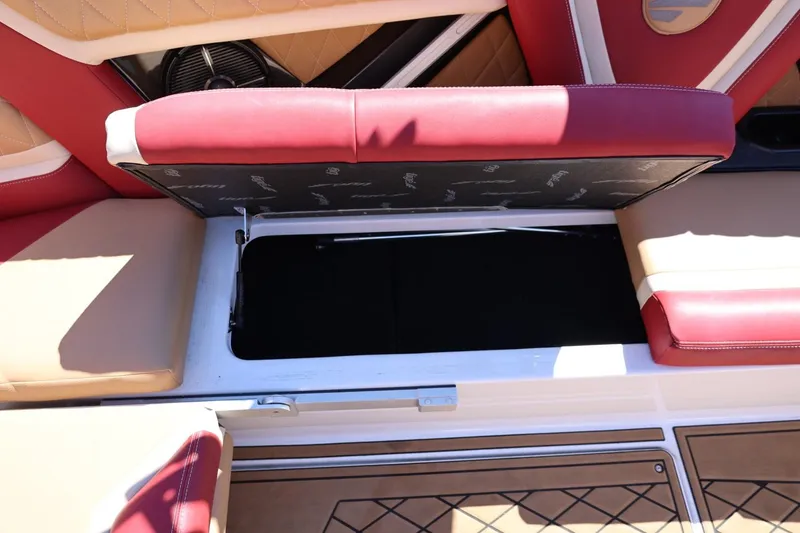 Slide: The Image of 2022 Tigé 25ZX boat interior with open storage compartment, red and beige seating. - 40