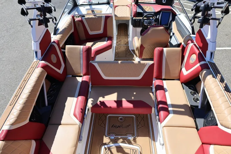 Slide: The Image of 2022 Tigé 25ZX boat interior with luxurious red and tan seating, advanced dashboard. - 44