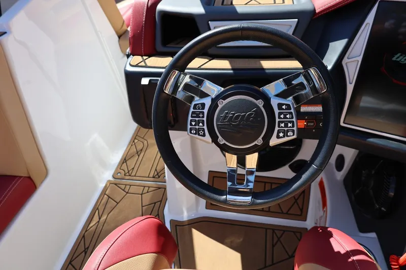 Slide: The Image of Steering wheel of 2022 Tigé 25ZX boat with control buttons and luxury interior. - 49