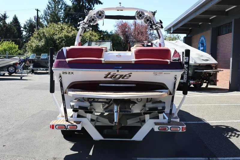 Slide: The Image of 2022 Tigé 25ZX boat rear view in a parking lot, showcasing sleek design. - 5