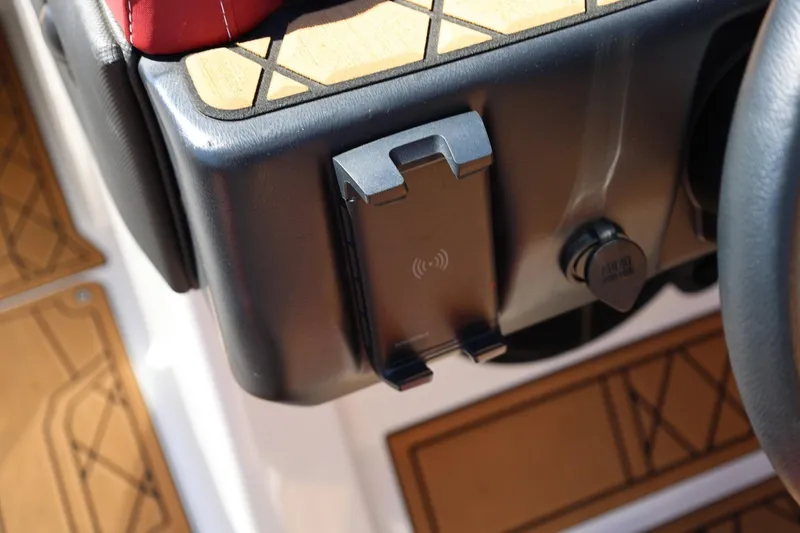 Slide: The Image of 2022 Tigé 25ZX boat dashboard with wireless phone charger and stylish wood accents. - 51