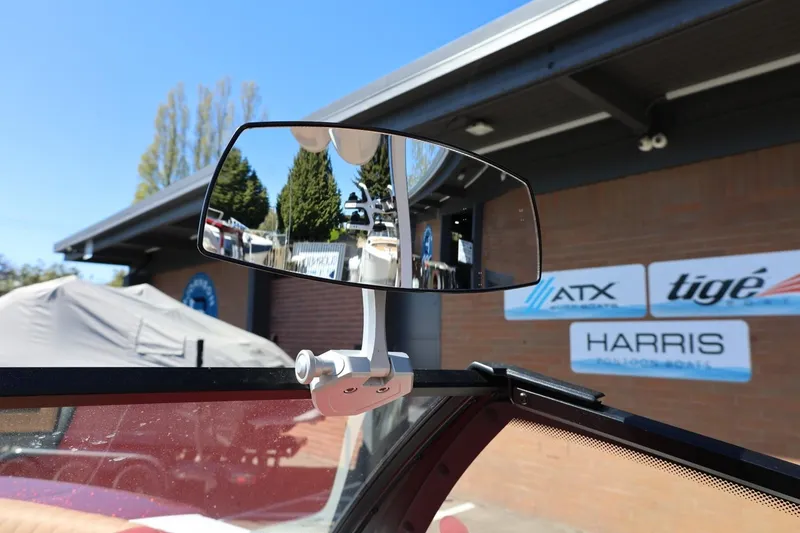 Slide: The Image of 2022 Tigé 25ZX boat mirror with dealership signs in the background. - 61