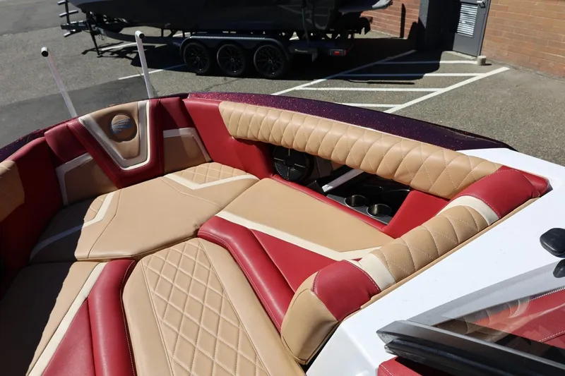 Slide: The Image of 2022 Tigé 25ZX boat interior with red and beige quilted seating. - 63