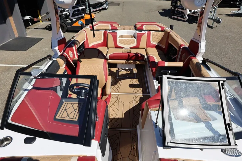 Slide: The Image of 2022 Tigé 25ZX boat interior with red and tan seating, open cockpit view. - 66