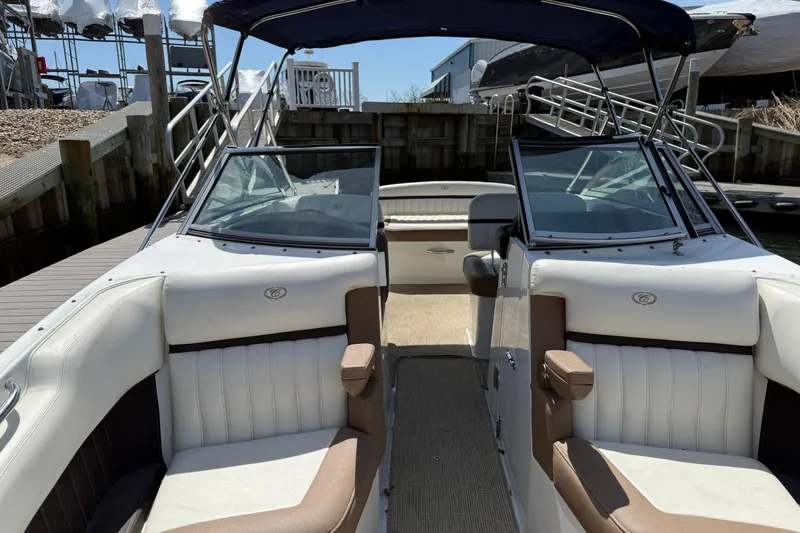 Slide: The Image of 2015 Cobalt 26SD boat interior with white and brown seating, docked at a marina. - 16
