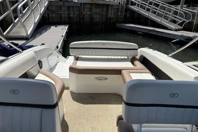 Slide: The Image of 2015 Cobalt 26SD boat interior with plush seating at a marina dock. - 9