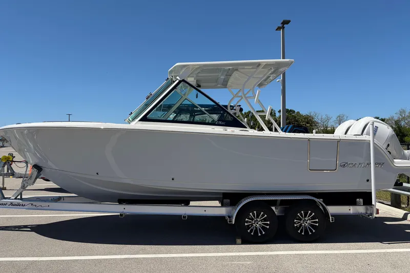 Slide: The Image of 2026 Sailfish 276 DC boat on trailer under clear blue sky. - 2