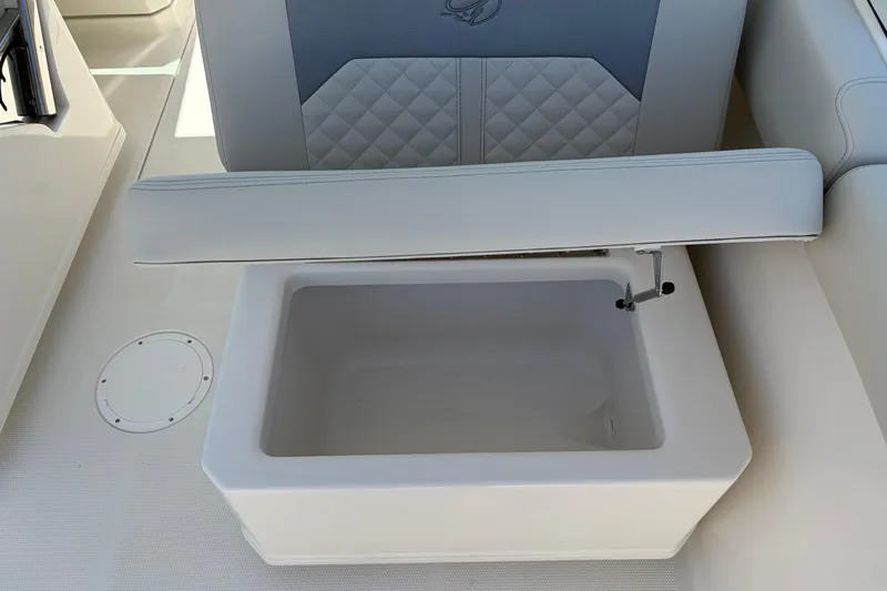 Slide: The Image of Open storage compartment on 2026 Sailfish 276 DC boat with cushioned seat. - 26
