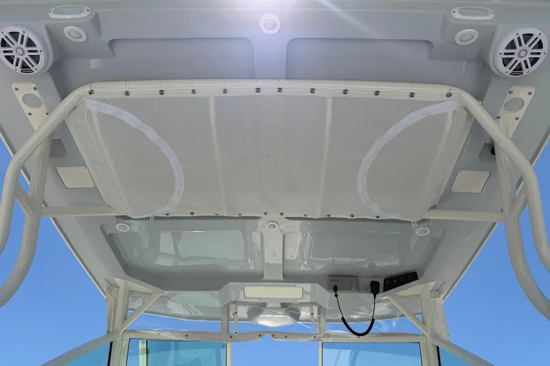 Slide: The Image of 2026 Sailfish 276 DC boat canopy with speakers and storage netting. - 33