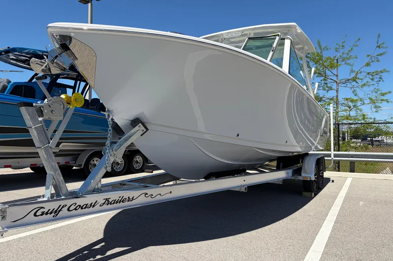 Slide: The Image of 2026 Sailfish 276 DC boat on Gulf Coast Trailers, parked outdoors under clear blue sky. - 4