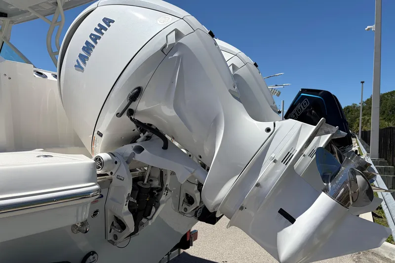 Slide: The Image of 2026 Sailfish 276 DC boat with Yamaha outboard engines, docked under clear blue sky. - 51