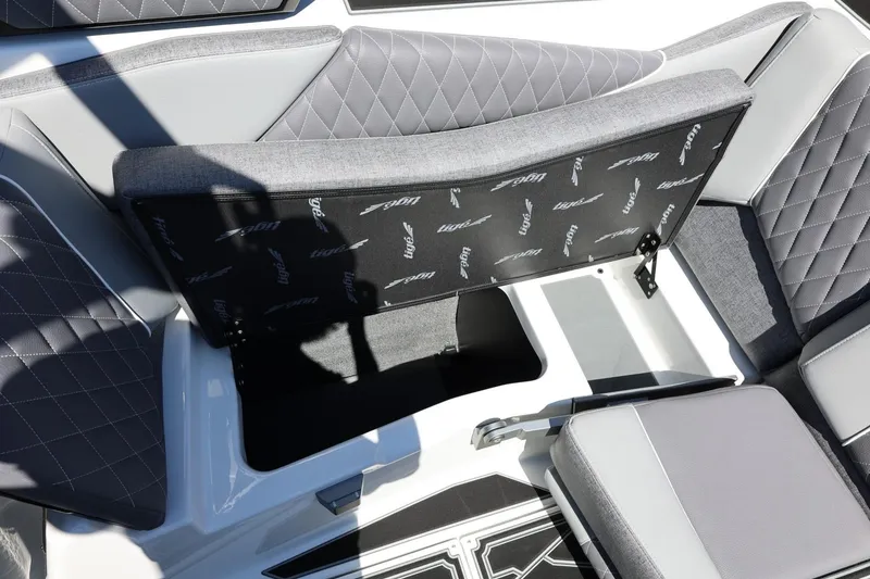 Slide: The Image of 2026 Tigé Z3 boat interior with open storage compartment and quilted gray seating. - 31