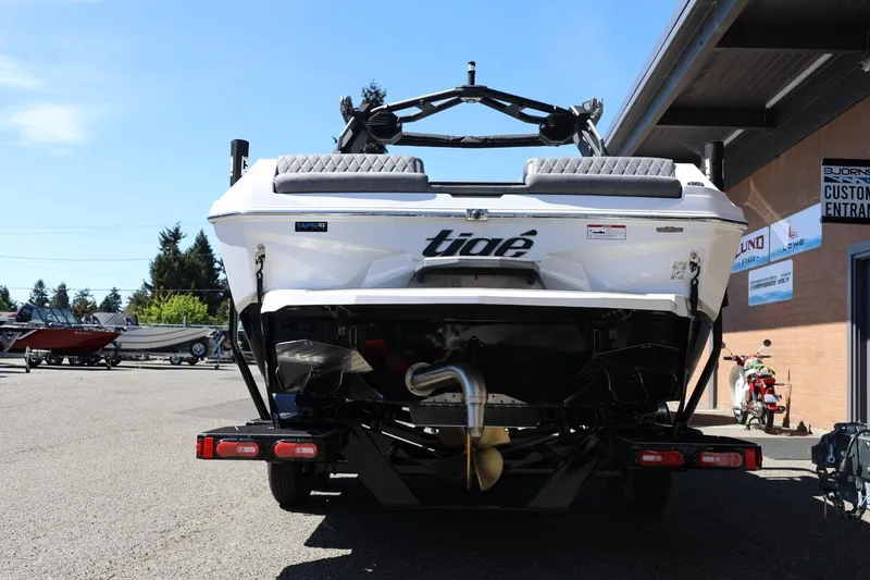 Slide: The Image of 2026 Tigé Z3 boat rear view at dealership, showcasing sleek design and trailer setup. - 6