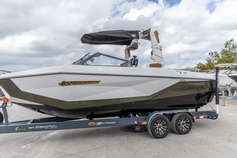 The Image of 2025 Nautique Super Air Nautique G23 boat on trailer, sleek design, parked outdoors. - 0