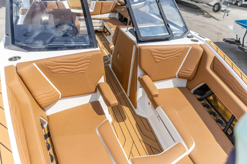Slide: The Image of Luxurious interior of 2025 Nautique Super Air Nautique G23 boat with tan seating. - 11