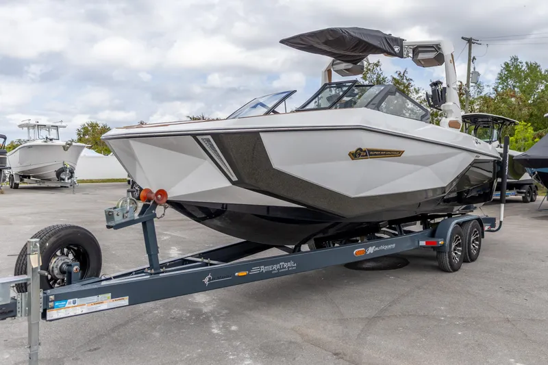 Slide: The Image of 2025 Nautique Super Air Nautique G23 boat on trailer, sleek design, parked outdoors. - 14