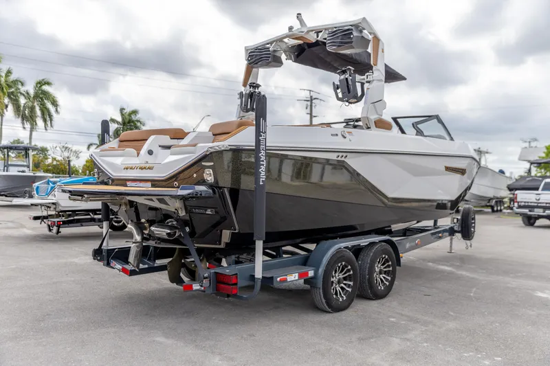 Slide: The Image of 2025 Nautique Super Air Nautique G23 boat on trailer, parked outdoors. - 17