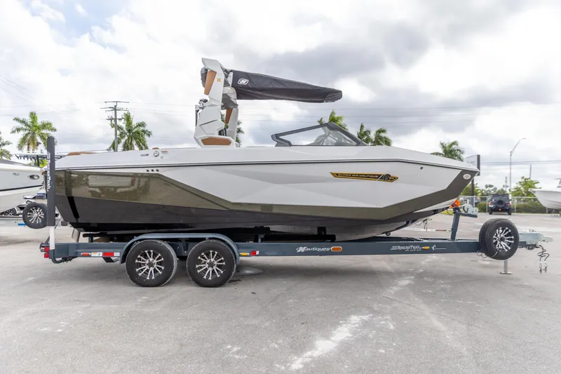 Slide: The Image of 2025 Nautique Super Air Nautique G23 boat on trailer, parked outdoors. - 18