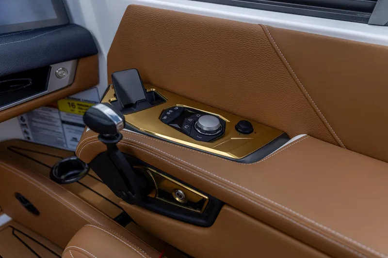 Slide: The Image of 2025 Nautique Super Air Nautique G23 interior control panel with luxurious brown leather finish. - 2