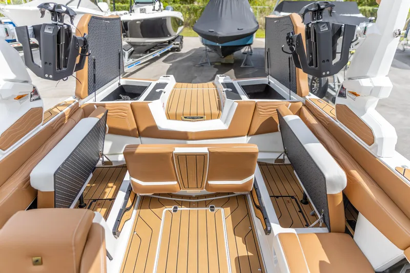Slide: The Image of 2025 Nautique Super Air Nautique G23 interior with tan seating and advanced wakeboard racks. - 24