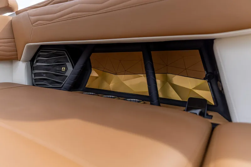 Slide: The Image of 2025 Nautique Super Air Nautique G23 interior with premium brown seating and speaker detail. - 25