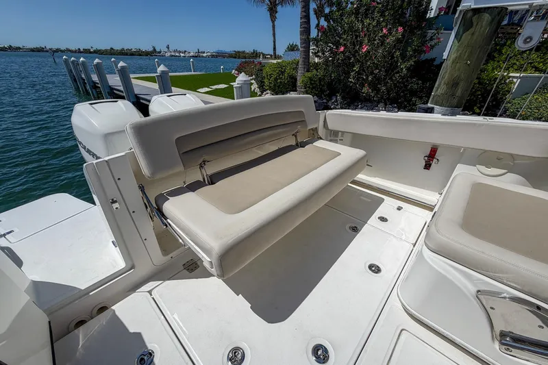Slide: The Image of 2017 Boston Whaler 320 Vantage boat interior with seating, docked by the water. - 17