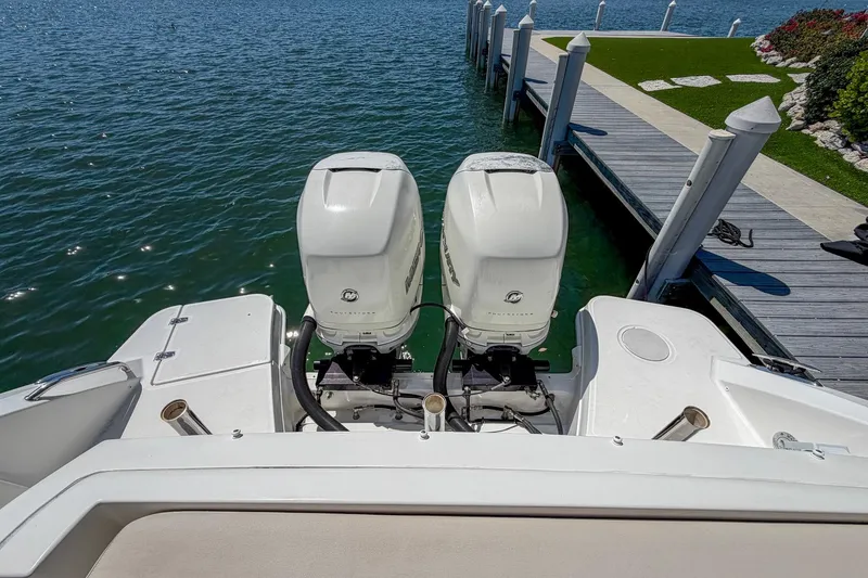 Slide: The Image of 2017 Boston Whaler 320 Vantage with twin outboard engines docked by the water. - 18