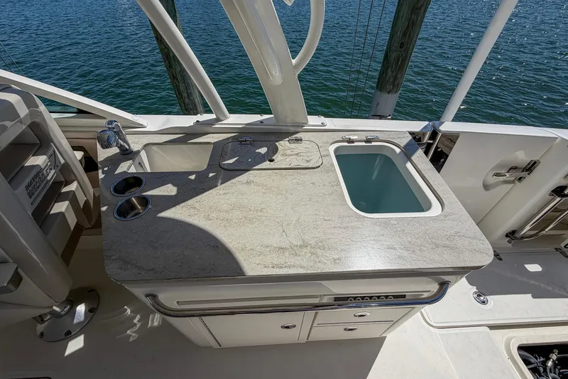 Slide: The Image of 2017 Boston Whaler 320 Vantage boat interior with sink and countertop, overlooking water. - 21