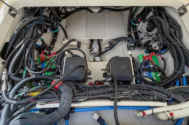Slide: The Image of Engine compartment of a 2017 Boston Whaler 320 Vantage, showcasing wiring and battery setup. - 22