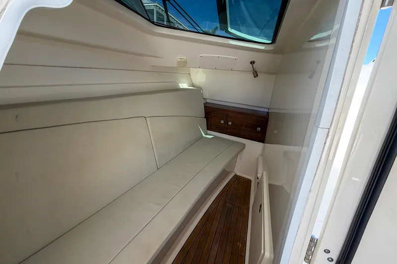 Slide: The Image of Interior cabin of 2017 Boston Whaler 320 Vantage with cushioned seating and wooden flooring. - 23