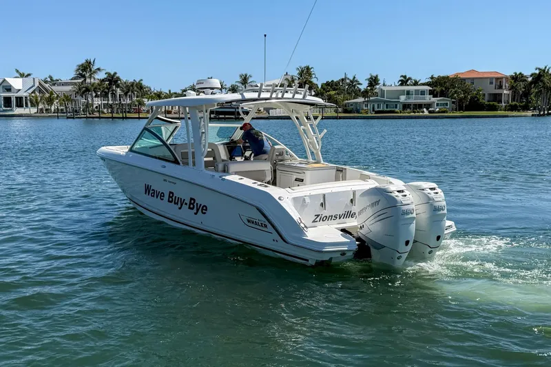 Slide: The Image of 2017 Boston Whaler 320 Vantage boat cruising on a sunny day near waterfront homes. - 32