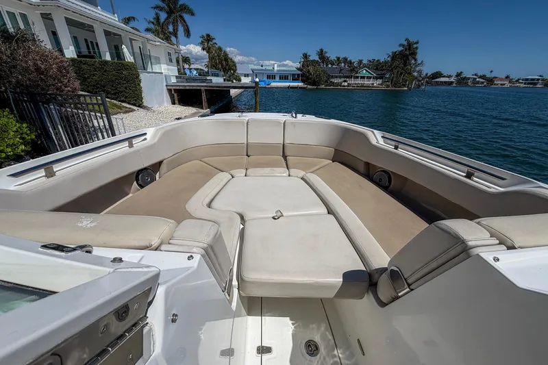 Slide: The Image of 2017 Boston Whaler 320 Vantage boat interior with spacious seating, docked by waterfront homes. - 5