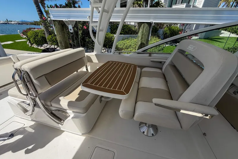 Slide: The Image of 2017 Boston Whaler 320 Vantage boat interior with seating and table, dockside view. - 8