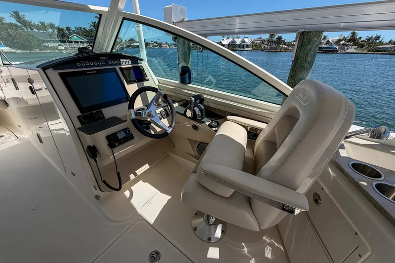 Slide: The Image of 2017 Boston Whaler 320 Vantage helm with steering wheel and navigation controls. - 9