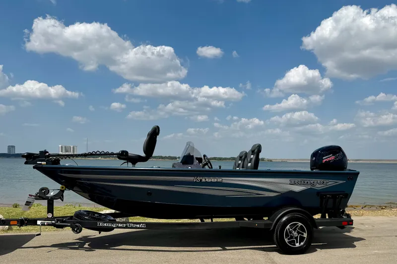 Slide: The Image of 2026 Ranger VS1682SC Angler boat by the lake under a cloudy sky. - 1